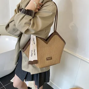 Détail du sac cabas tissé avec ouverture en V et ruban décoratif élégant de mode