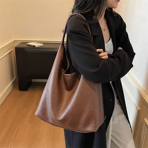 Detail of deep brown pebbled leather texture on a large capacity vintage tote bag