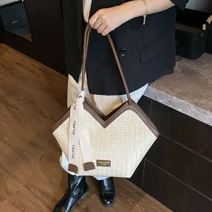 Détail du sac cabas tissé avec garniture en cuir marron et ruban décoratif