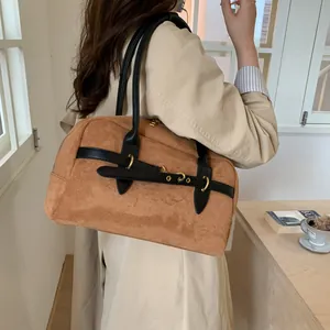 Caramel suede handbag detail showing vintage black leather strap and gold metal ring buckle