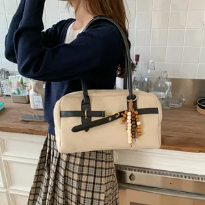 Detail of retro cream suede handbag with elegant wood bead tassel and gold buckle