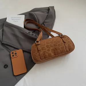 Braune Bowlingtasche mit Leopardenmuster, Markenlogo und Wildlederoptik im Alltag