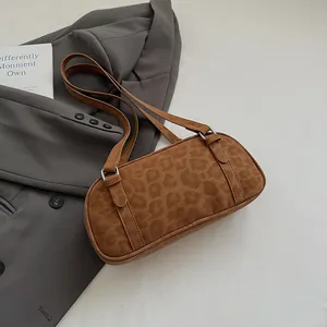 Detailansicht der braunen Bowlingtasche mit Leopardenmuster auf anthrazitfarbenem Blazer