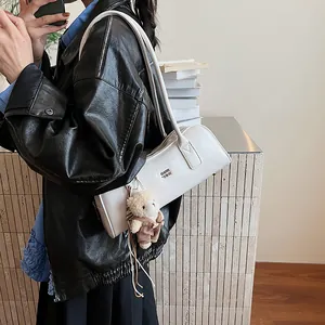 Weiße Boston Schultertasche aus Leder mit einem süßen Bärenanhänger an der Seite
