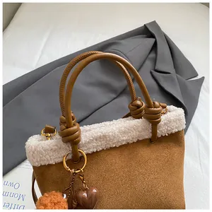 Nahaufnahme der braunen Wildledertasche mit weißem Lammfellbesatz und Knotengriff-Detail