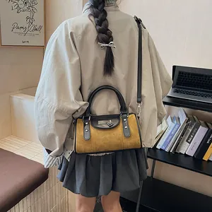 Detailed view of mustard yellow suede crossbody bag with vintage heart lock and strap