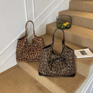Sac seau chic à imprimé léopard avec nœud et finitions en cuir sur l'escalier