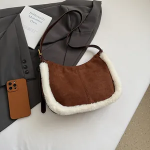 Detail of brown suede hobo bag with white faux fur trim and adjustable leather strap