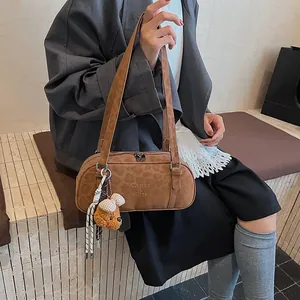 Details der braunen Bowlingtasche mit Leopardenprägung und Plüschbär-Anhänger