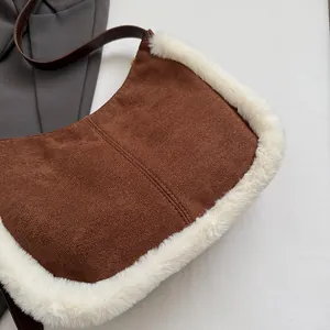 Close-up of brown suede underarm bag with white faux fur trim and leather strap