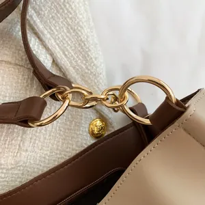 Detail of two-tone faux leather tote bag with gold rings and fine stitching detail