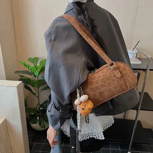 Schicke Schultertasche mit Leopardenmuster und Bärenanhänger, von Model getragen