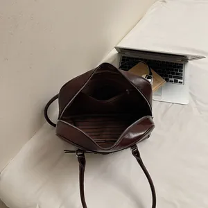Interno borsa in pelle marrone con fodera a righe e tasca interna con cerniera