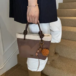 Detail der Wildleder-Beuteltasche mit Pelzbesatz, Lederknotengriff und süßen Anhängern