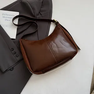 Detail view of coffee leather hobo bag with brown suede patchwork and white faux fur trim