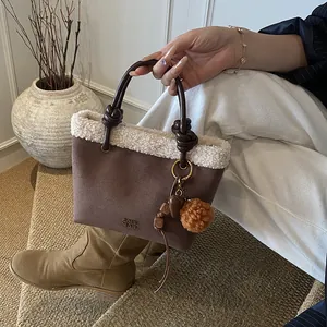 Details der Wildleder-Beuteltasche mit Pelzbesatz, Knotengriff und Anhänger