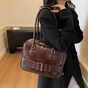 Dettaglio della borsa a spalla marrone retrò con fibbie metalliche e chiusura a zip