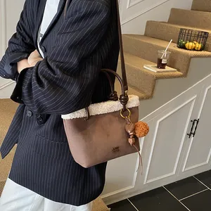 Detail der Wildleder-Beuteltasche mit Pelzbesatz, COIN-Logo und Herzanhänger