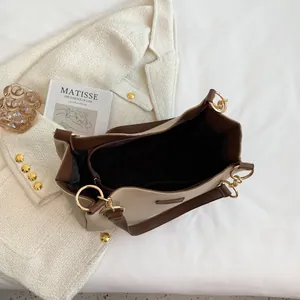 Interior detail of two-tone tote bag featuring multiple compartments and zip pocket