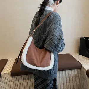 Detail of brown suede crescent bag with fuzzy faux fur trim and adjustable leather strap
