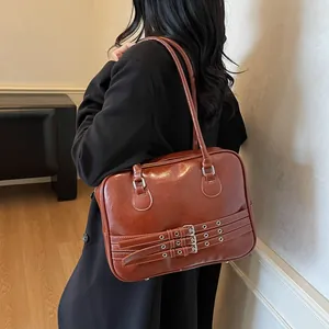 Dettaglio borsa a spalla in pelle lucida marrone con fibbie vintage in argento