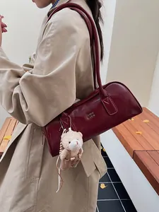 Vintage bordeauxrote Zylindertasche mit Bärenanhänger und metallischem Logo-Akzent
