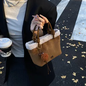Detail der braunen Wildledertasche mit weißem Teddyfell-Besatz und geknotetem Griff
