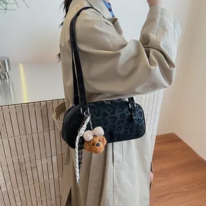 Detail der schwarzen Bowling-Tasche mit Leopardenmuster, Teddy-Anhänger und Knotendetail