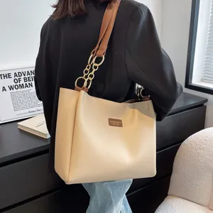 Chic beige tote bag with brown straps shown on shoulder during daily city commute