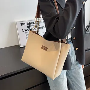 Macro detail of beige tote bag showing high-quality synthetic leather and golden chain links