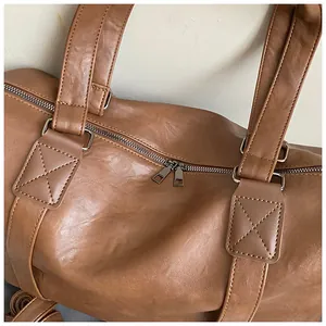 Detailed macro view of brown PU leather texture, metallic zippers, and reinforced stitching