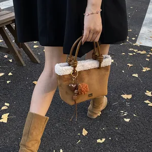 Detail der Wildleder-Beuteltasche mit Plüschbesatz Herzanhänger und Pelzbommel