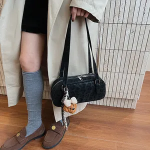Minimalistische schwarze Bowlingtasche mit Leopardenmuster und Bärenanhänger im Outfit