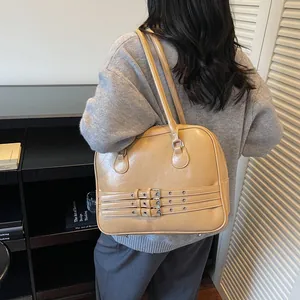 Dettaglio della borsa a spalla in pelle kaki con tre cinturini regolabili e fibbie metalliche