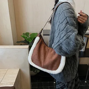 Detail of brown suede shoulder bag with white faux fur trim and adjustable leather strap