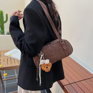 Detail der Bowling-Tasche mit Leopardenmuster, Logo-Prägung und süßem Teddybär-Anhänger