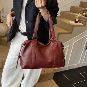 Detail view of large burgundy faux leather tote bag with stylish stitching and drawstrings
