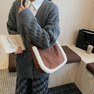 Detail of brown suede shoulder bag with white faux fur trim on a female model