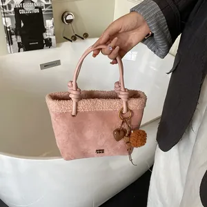 Rosa Wildleder-Eimertasche mit Plüschbesatz und dekorativem Herzanhänger-Detail