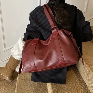 Detailed close-up of burgundy tote bag showing reinforced stitching and textured leather