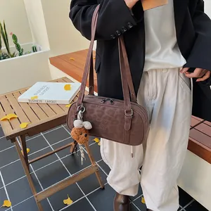 Detail der Schultertasche mit Leopardenmuster, Bärenanhänger und Reißverschluss