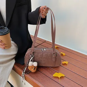 Detailansicht der braunen matten Bowlingtasche mit Plüschbär auf einer Parkbank
