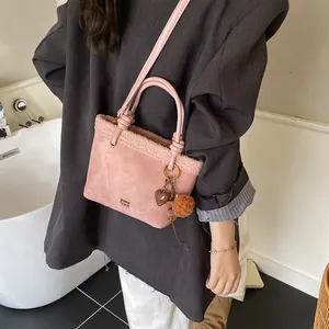 Detail der rosa Wildleder-Beuteltasche mit Lammfellbesatz und Herz-Anhänger