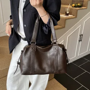 Macro view of textured dark brown faux leather travel tote bag with double shoulder straps