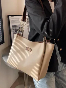 Fashionable beige faux leather tote bag with brown chain straps for daily commute use