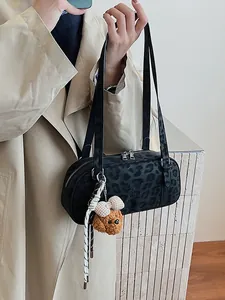 Minimalistische schwarze Handtasche mit Leopardenmuster, Plüsch-Anhänger und Silberreißverschluss