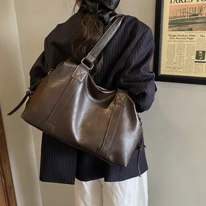Detail of vintage brown PU leather tote bag with reinforced stitching and matte texture