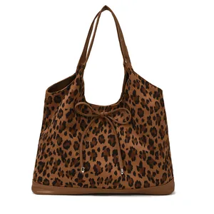 Sac cabas léopard chic avec bordures en cuir et nœud décoratif sur fond blanc immaculé