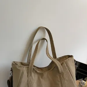 Detail showing khaki textured nylon fabric and metallic hardware on large tote bag