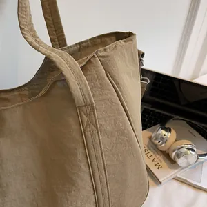 Close-up of khaki tote bag with textured nylon fabric and side pocket for daily commuting